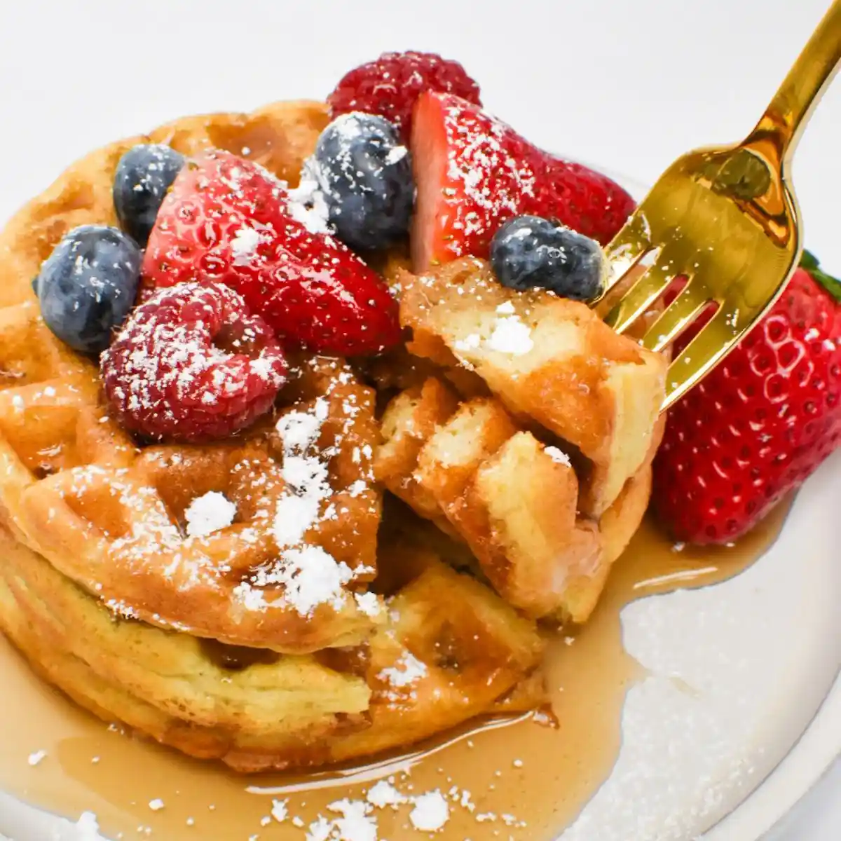 Quick Sourdough Discard Waffles Recipe 2 Crispy golden sourdough discard waffles stacked on a plate with fresh berries and maple syrup