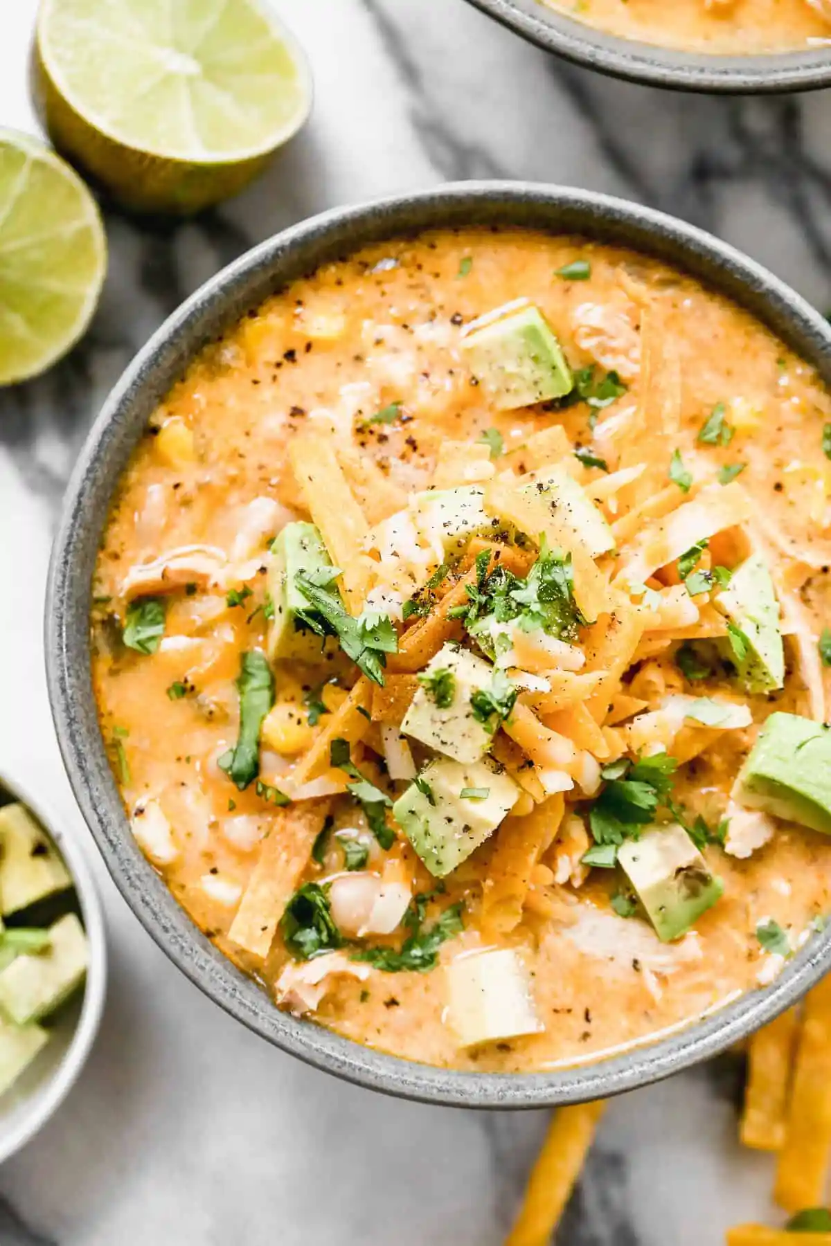 Best High Protein White Chicken Chili Recipe 2 Creamy white chicken chili garnished with fresh cilantro and avocado slices