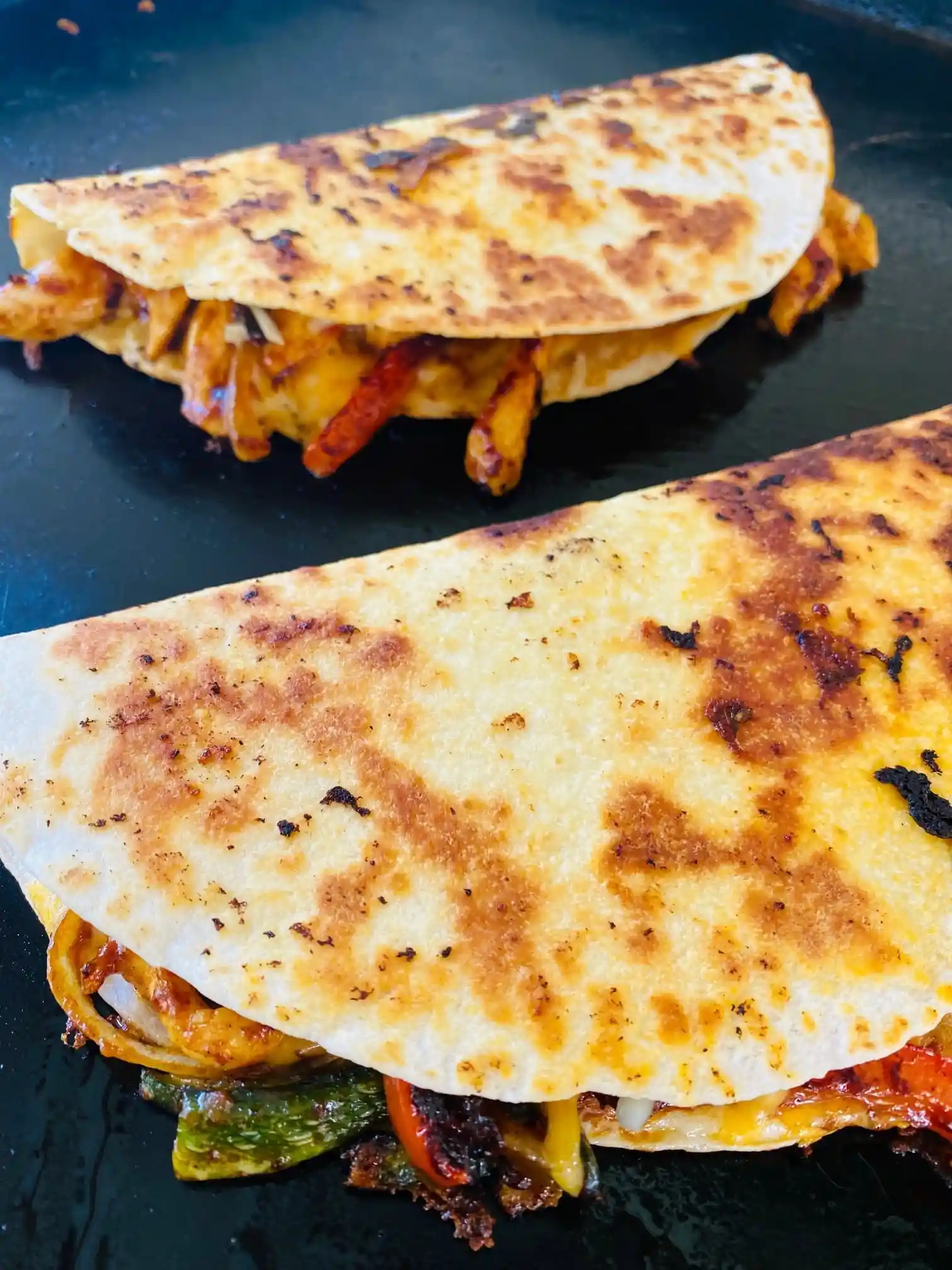 The Ultimate Blackstone Chicken Quesadillas Recipe 2 Crispy Blackstone Chicken Fajita Quesadillas on a griddle
